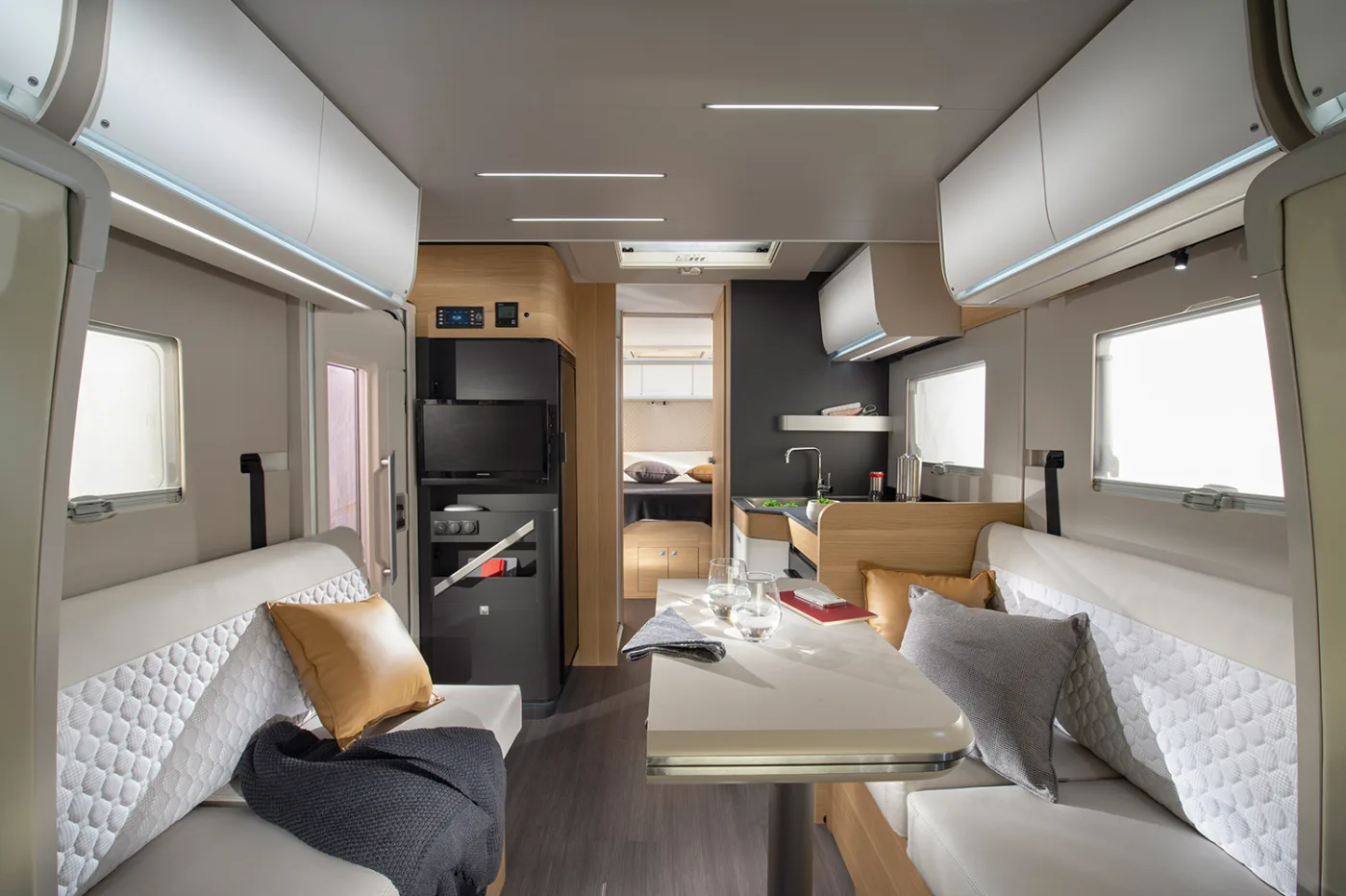Intérieur d'un camping-car Neo-NOMAD : dinette lumineuse, cuisine équipée et couchage au fond