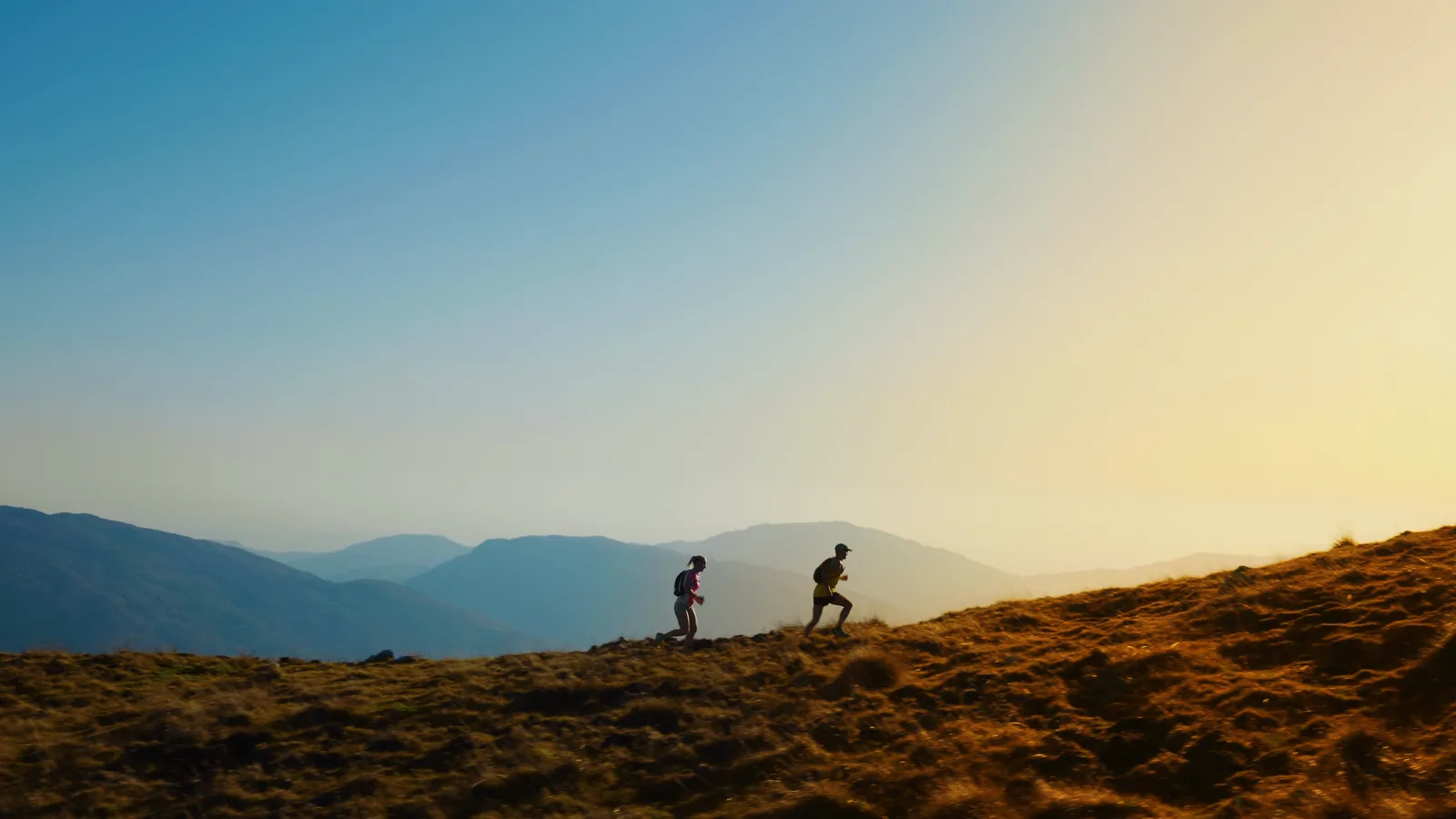 Trail runners sur une crête de la région Sud Provence-Alpes-Côte-d’Azur au coucher du soleil — formule Outdoor NOMAD